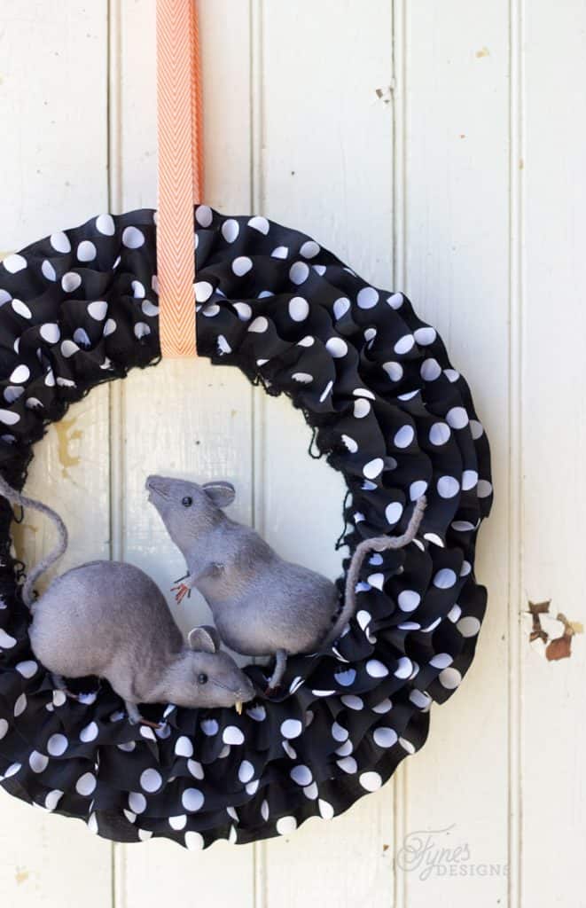 Black rats climbing across a fall wreath for Halloween decor.