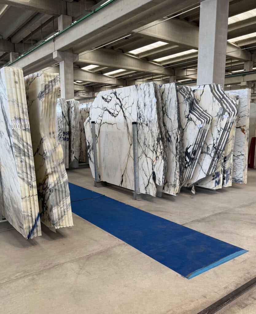 A wide view of natural stone slabs displayed in rows at Marmi Orobici Graniti in Italy.