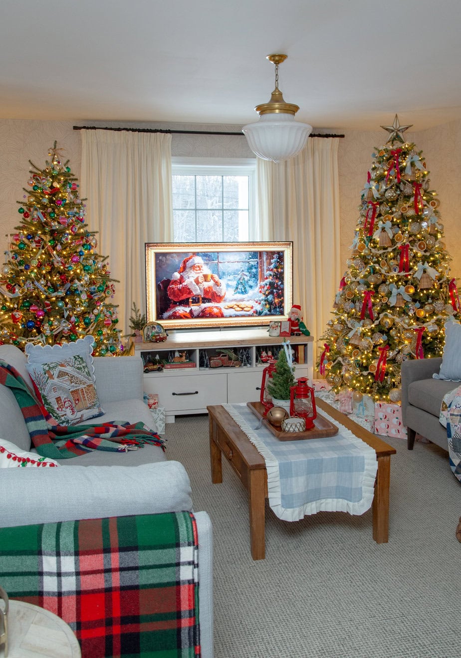 Open-concept living and dining room decorated with multiple Christmas trees, a festive table setting, and warm twinkle lights.